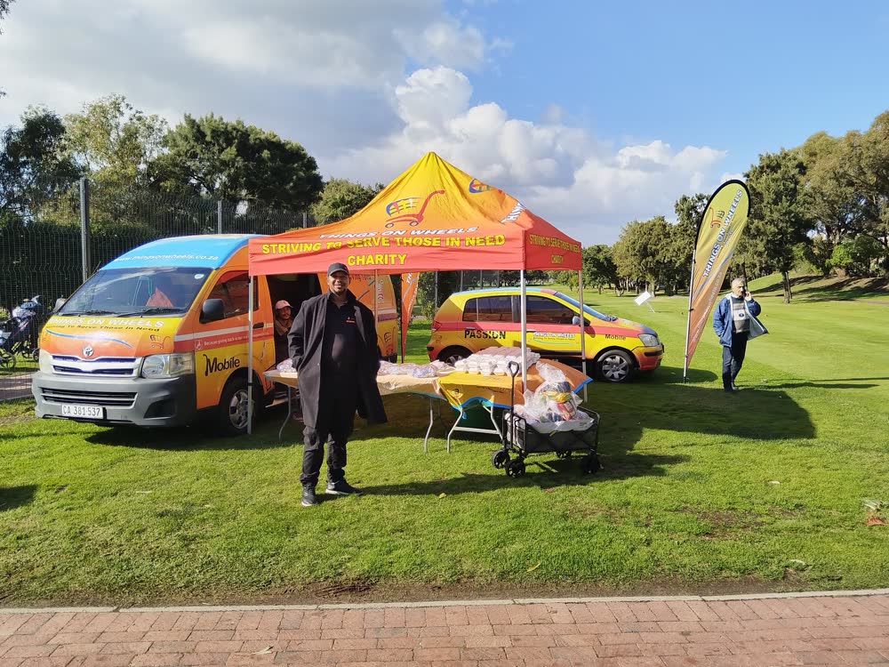 Things On Wheels team member with branded vehicles at an event
